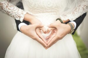 Les deux mains jointes des mariés forment un coeur et représente leur amour